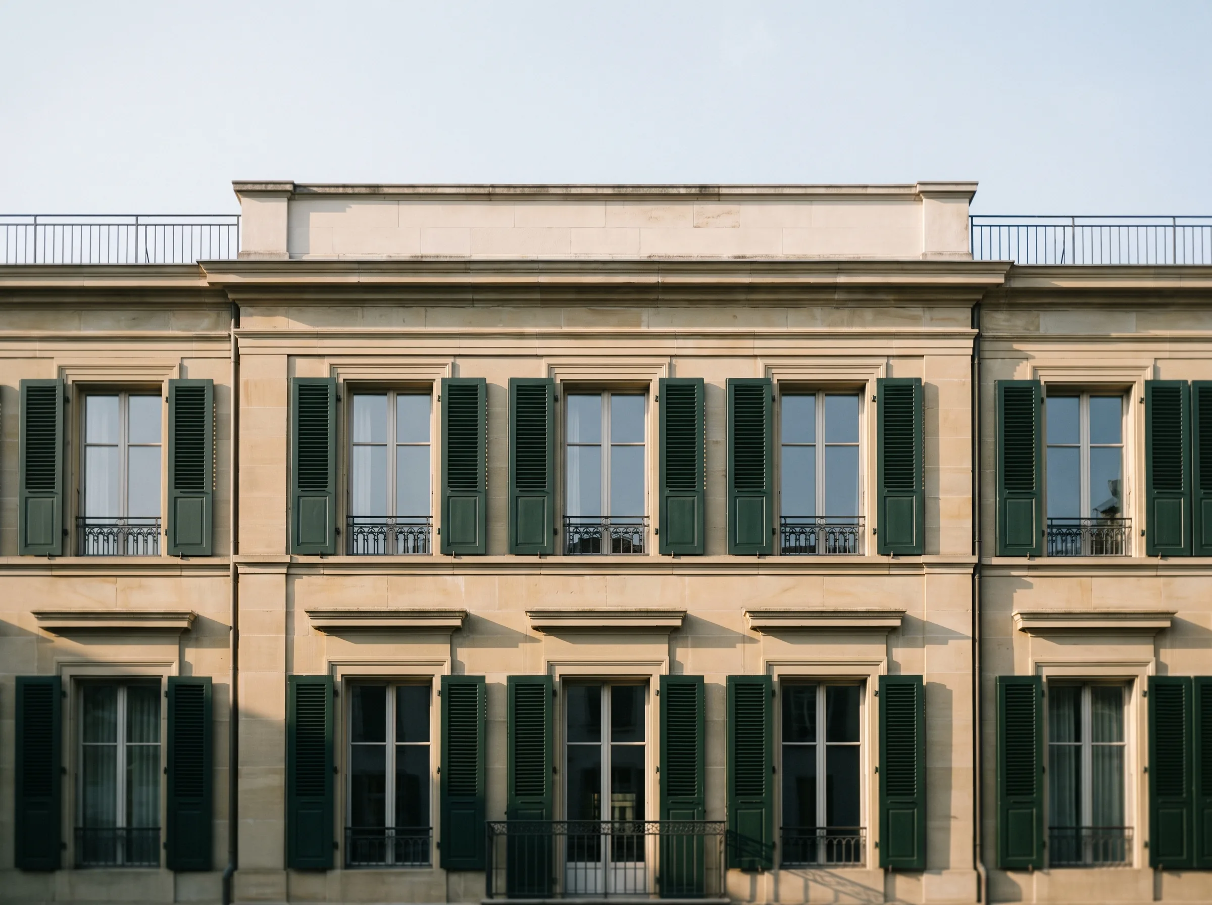 Fassade eines klassizistischen Stadthauses mit dunkelgrünen Fensterläden