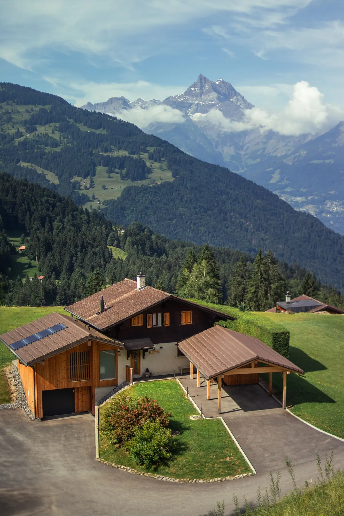 Modernes Holzhaus am Hang vor Bergkulisse